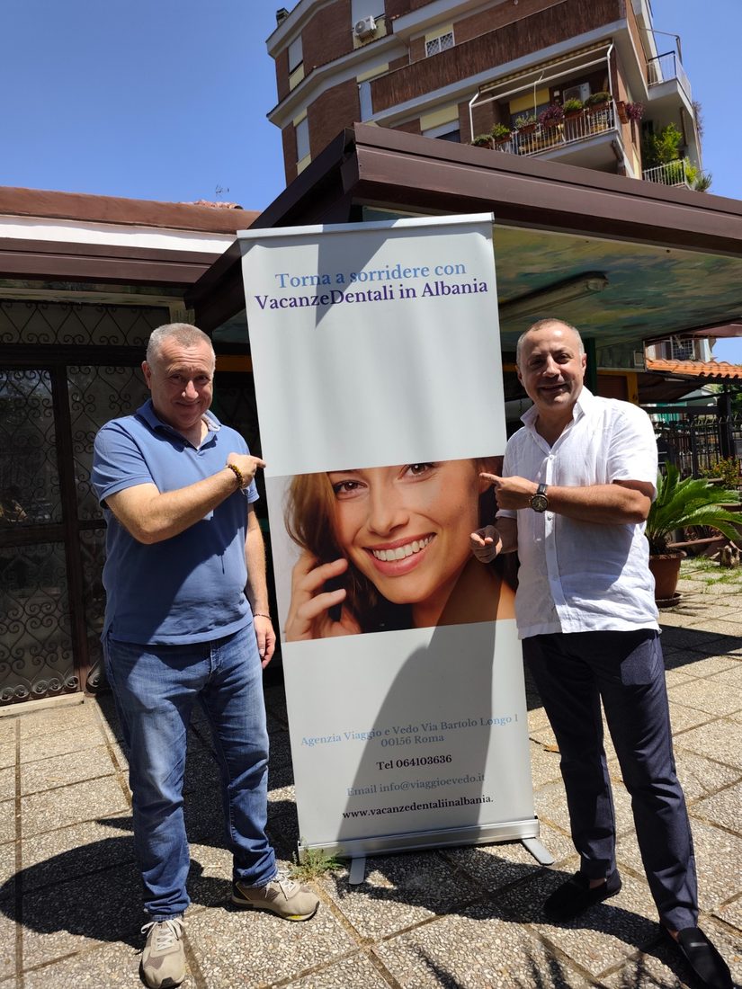 Gianluigi Leoni davanti all'agenzia con il roll-up Vacanze Dentali in Albania