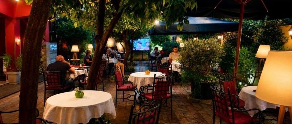 Il giardino-ristorante della Vila 15 la sera, con i tavoli apparecchiati