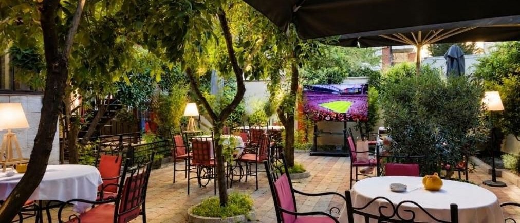 Il giardino-ristorante della Vila 15 di giorno, sotto gli alberi